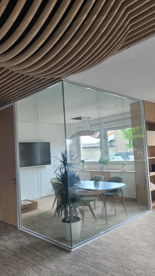 Salle de réunion vitrée sous un plafond courbe à lames de bois