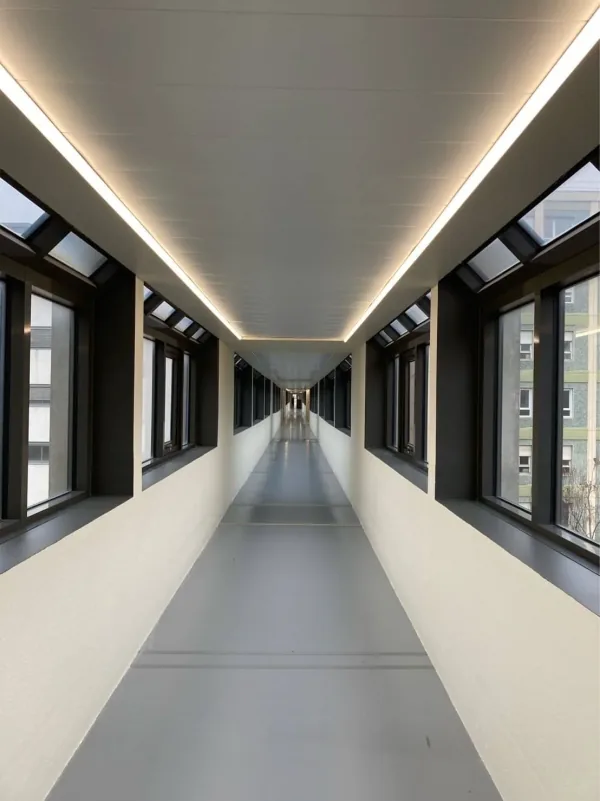 Long couloir sous un plafond blanc à ligne lumineuse